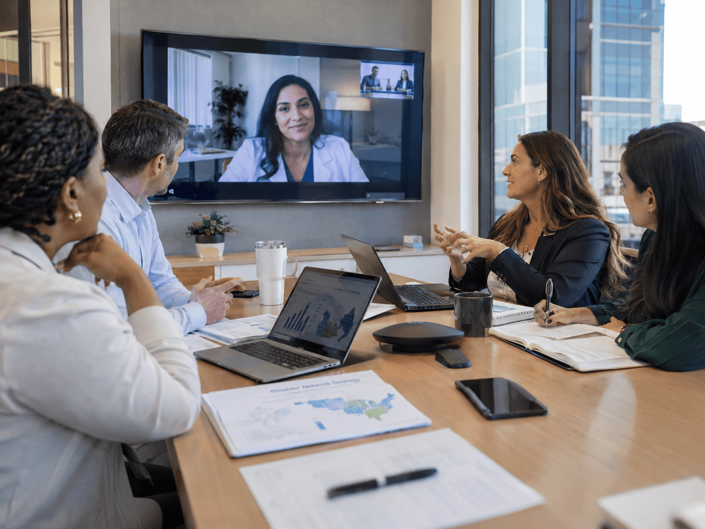 A provider network strategy session, with market coverage analysis on the table and a clinical leader joining by video.